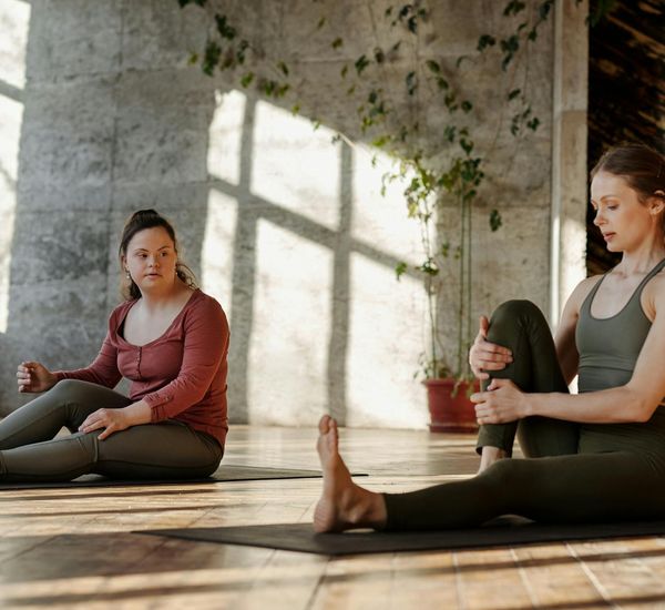 Person doing a gentle stretching exercise in a bright, sunlit room.
