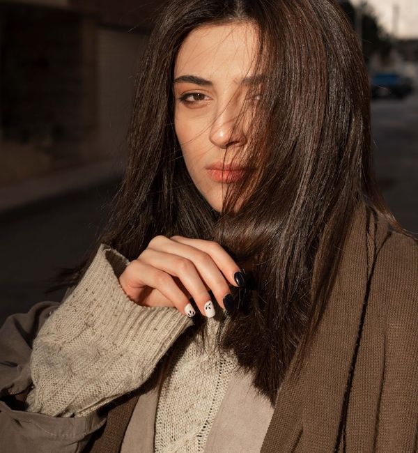 Woman feeling energetic and happy outdoors with a serene background.